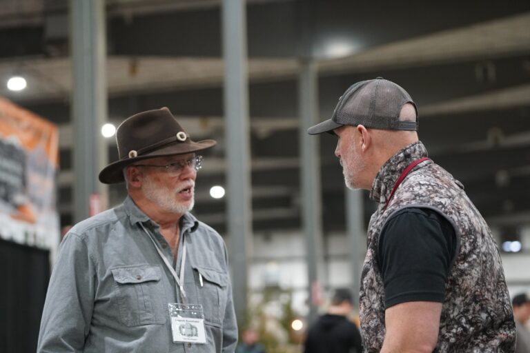 Two men discussing at the Midwest Sportsmen Classic expo.