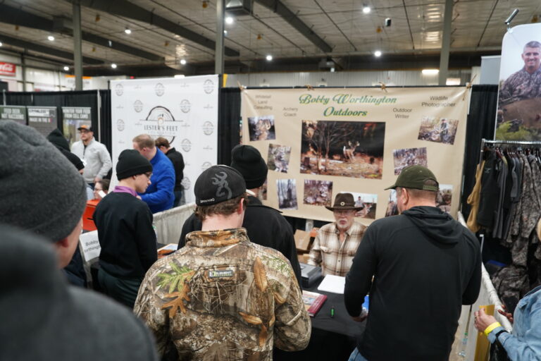Visitors exploring booths, including Bobby Worthington Outdoors, at the bustling Midwest Sportsmen Classic expo.